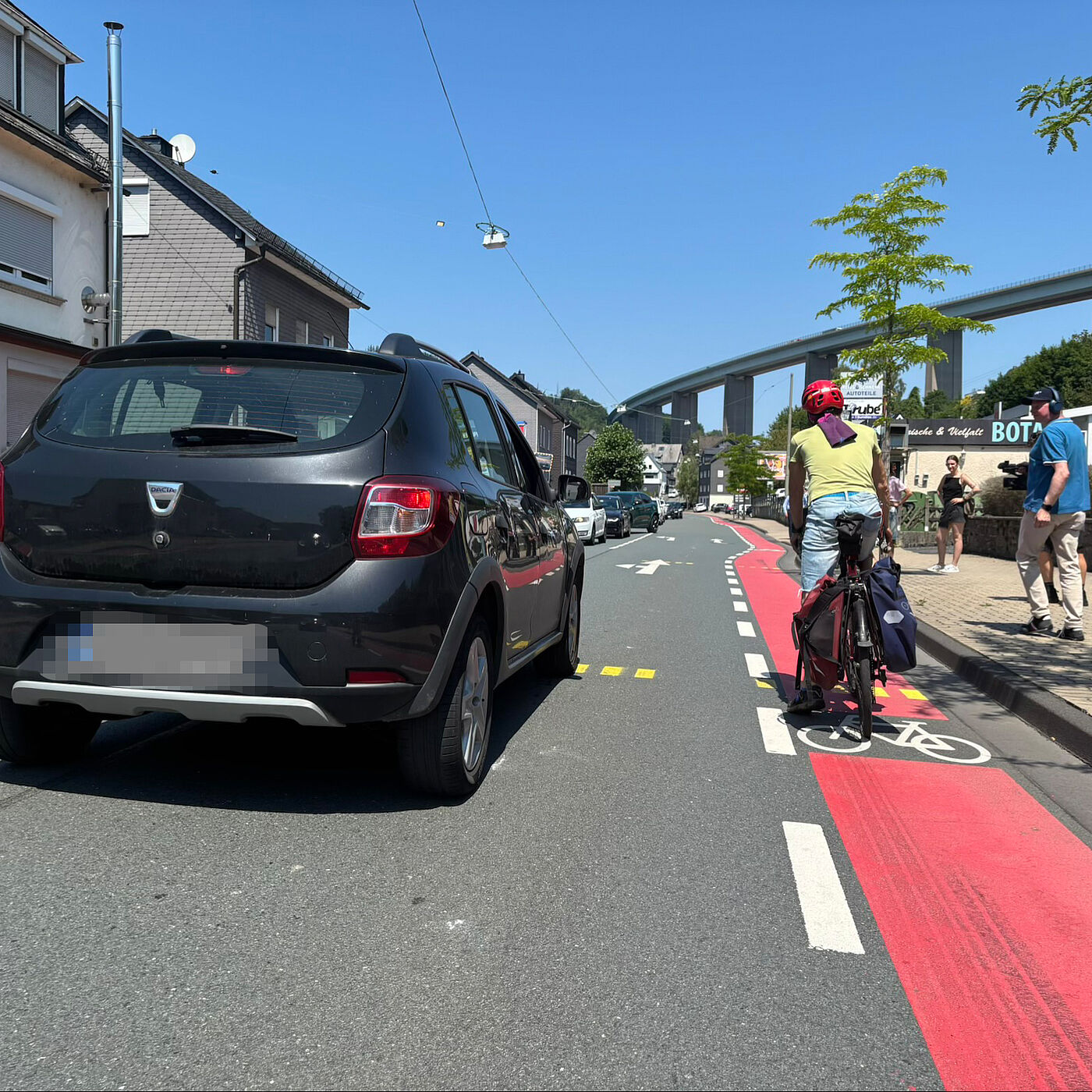 Auto überholt Radfahrer Eine Person im Auto überholt einen Radfahrer in Siegen-Eiserfeld auf der Eiserfelder Straße.